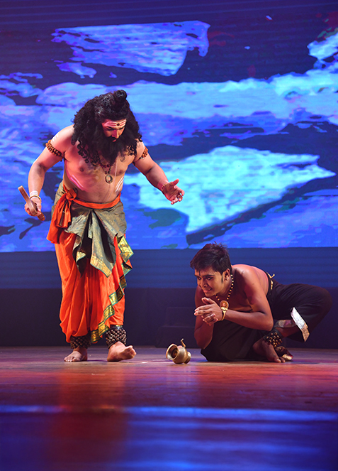 Stage still — Agasthya Rishi, ensemble in performance, warm wash