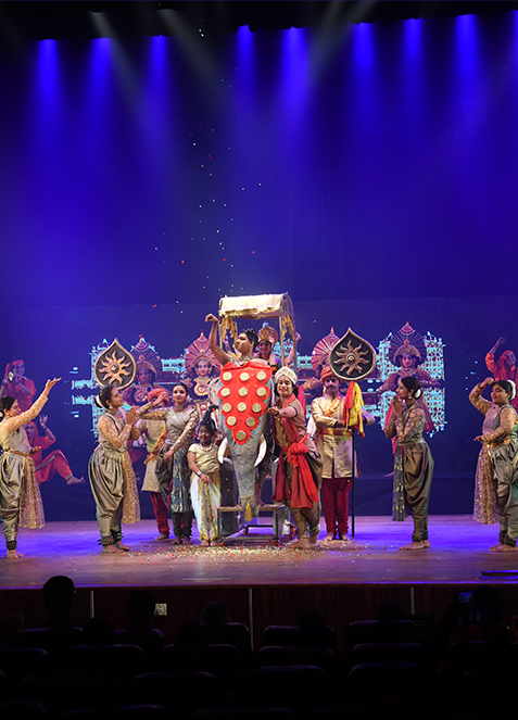 Stage still — Chitrapata, ensemble in performance, warm wash