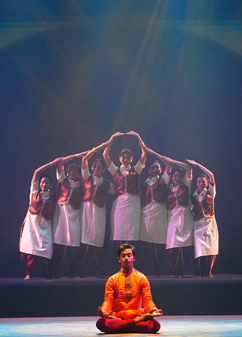 Stage still — Harmony, ensemble in performance, warm wash
