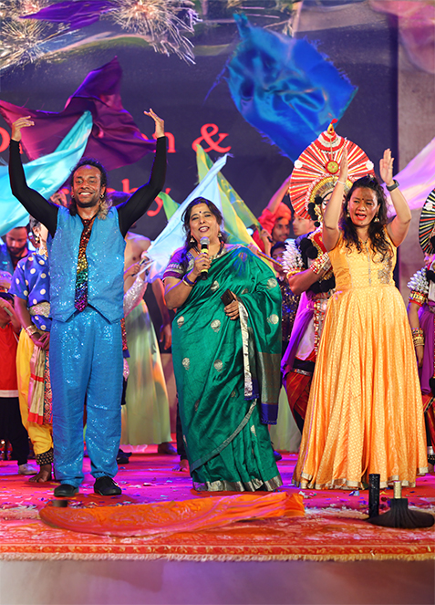 Stage still — Vasudhika Kutumbam, ensemble in performance, warm wash